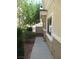 View of side yard with cement path and rock landscaping plus mature foliage at 3208 Regal Swan Pl # 3, North Las Vegas, NV 89084