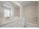 Bright bathroom featuring double sinks, a large mirror, a bathtub, and tile surround at 3270 Trabia Ave, Henderson, NV 89044