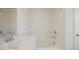Tiled shower-tub combo with built-in shelves, paired with white cabinets and countertops at 3270 Trabia Ave, Henderson, NV 89044