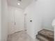 Bright entryway with tiled floor, white walls, and staircase with carpeted steps leading to the upper level at 3270 Trabia Ave, Henderson, NV 89044