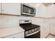 Stainless steel oven and microwave in a well-lit kitchen with white cabinets and light quartz countertops at 3270 Trabia Ave, Henderson, NV 89044