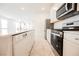Modern kitchen with stainless steel appliances, white cabinets and stone countertops with view to dining area at 3270 Trabia Ave, Henderson, NV 89044