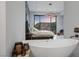 Bright bedroom suite featuring a soaking tub, large windows, and mountain views at 383 Solitude Peak Ln, Henderson, NV 89012
