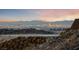 City skyline view at sunset from atop a rock hillside at 383 Solitude Peak Ln, Henderson, NV 89012