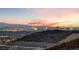 Sunset view of the city skyline from atop a rocky hill at 383 Solitude Peak Ln, Henderson, NV 89012