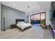 Modern bedroom featuring an accent wall, recessed lighting, and sliding glass doors that open to scenic desert views at 383 Solitude Peak Ln, Henderson, NV 89012