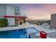 Outdoor kitchen, pool, and sunset views create a luxurious outdoor experience at 383 Solitude Peak Ln, Henderson, NV 89012