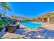 An eye-level shot of the pool area showcasing blue water, comfortable seating, and a well-maintained recreational space at 383 Solitude Peak Ln, Henderson, NV 89012