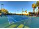 Well-maintained tennis court with ample lighting for evening play, surrounded by lush green landscaping at 383 Solitude Peak Ln, Henderson, NV 89012
