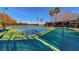 Well-maintained tennis court with palm trees and new fence provides a great recreational amenity at 383 Solitude Peak Ln, Henderson, NV 89012