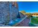 A stunning water feature with a stacked stone wall and lush landscaping, adding beauty to the outdoor space at 383 Solitude Peak Ln, Henderson, NV 89012