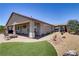 Wide backyard with a covered patio, artificial turf, and desert-friendly landscaping at 3906 Jacob Lake Cir, Las Vegas, NV 89118