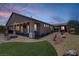 Twilight view of backyard with a covered patio, artificial turf, and landscaping at 3906 Jacob Lake Cir, Las Vegas, NV 89118