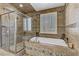 Relaxing bathroom featuring a soaking tub, walk-in shower, and tile accents at 3906 Jacob Lake Cir, Las Vegas, NV 89118