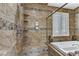 Elegant bathroom with tile accents, glass shower door, and a luxurious soaking tub near a window at 3906 Jacob Lake Cir, Las Vegas, NV 89118