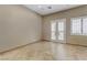 An empty room featuring tan walls and tile flooring, and a double door leading to the exterior at 3906 Jacob Lake Cir, Las Vegas, NV 89118