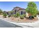 Attractive home exterior with lush landscaping, a three-car garage, and desert rock at 3906 Jacob Lake Cir, Las Vegas, NV 89118
