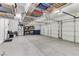 A spacious garage with epoxy flooring, storage racks, and multiple doors, perfect for vehicles and storage at 3906 Jacob Lake Cir, Las Vegas, NV 89118