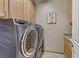 A functional laundry room with a modern washer and dryer set, storage cabinets, and granite countertops at 3906 Jacob Lake Cir, Las Vegas, NV 89118