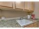 A useful laundry sink with a granite countertop, storage cabinets, and a convenient paper towel holder at 3906 Jacob Lake Cir, Las Vegas, NV 89118