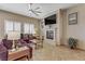 Comfortable living room with a fireplace, tile floors, and ample natural light at 3906 Jacob Lake Cir, Las Vegas, NV 89118