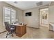 Bright home office with wood desk, modern TV, and shuttered windows providing ample natural light at 3906 Jacob Lake Cir, Las Vegas, NV 89118