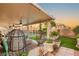 Covered back patio featuring comfortable seating and a view of the lush, landscaped backyard and pool at 3950 Candleglow Ct, Las Vegas, NV 89147