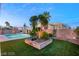 A backyard with a green lawn, pool, landscaping, and ample space for outdoor activities at 3950 Candleglow Ct, Las Vegas, NV 89147