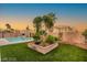 A backyard with a green lawn, pool, landscaping, and ample space for outdoor activities at 3950 Candleglow Ct, Las Vegas, NV 89147
