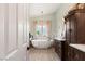 Bright bathroom featuring a modern soaking tub under a chandelier, with stylish vanity and fixtures at 3950 Candleglow Ct, Las Vegas, NV 89147
