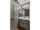 Well-maintained bathroom with a single sink vanity, gray cabinets, and a framed mirror at 3950 Candleglow Ct, Las Vegas, NV 89147