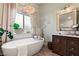 A luxurious soaking tub and vanity create a spa-like experience in this naturally lit bathroom at 3950 Candleglow Ct, Las Vegas, NV 89147