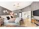 Spacious primary bedroom with a large bed, vaulted ceilings, a chandelier and a gray accent wall at 3950 Candleglow Ct, Las Vegas, NV 89147