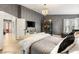 Spacious primary bedroom with a large bed, vaulted ceilings, a chandelier and a gray accent wall at 3950 Candleglow Ct, Las Vegas, NV 89147
