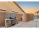 An outdoor kitchen with a built-in grill and stylish backsplash, perfect for entertaining at 3950 Candleglow Ct, Las Vegas, NV 89147