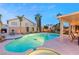 Inviting backyard featuring a pool, spa, fireplace, and covered patio with dining at 3950 Candleglow Ct, Las Vegas, NV 89147