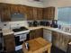 Kitchen with stainless steel appliances, wood cabinets, and tile countertops at 4607 Chestnut Blaze Dr, North Las Vegas, NV 89032