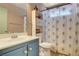 Bright bathroom featuring a blue vanity, patterned shower curtain, and decorative storage, offering a fresh, clean space at 5019 Lancaster Dr, Las Vegas, NV 89120