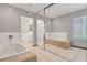 Bright bathroom featuring a soaking tub, tiled floor, and a glass door shower at 5019 Lancaster Dr, Las Vegas, NV 89120