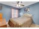 Comfortable bedroom featuring light brown walls, a floral comforter, and a window with sheer pink curtains at 5019 Lancaster Dr, Las Vegas, NV 89120