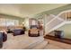 Open-concept living room with a neutral color palette, comfortable seating, and a staircase at 5019 Lancaster Dr, Las Vegas, NV 89120