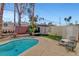 In-ground pool in backyard surrounded by privacy fence, mature trees, and patio furniture at 5019 Lancaster Dr, Las Vegas, NV 89120