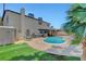 An in-ground pool in a backyard with green grass and a privacy fence at 5019 Lancaster Dr, Las Vegas, NV 89120