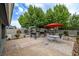 Beautiful backyard featuring a built-in barbecue, stone pavers, and a dining area under a red umbrella at 5200 Wheatland Dr, Pahrump, NV 89061