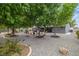 Wide view of landscaped backyard featuring mature trees, gravel landscaping and outdoor barbeque area at 5200 Wheatland Dr, Pahrump, NV 89061