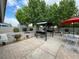 Relaxing backyard with a built-in grill, lush trees, and an outdoor dining area under a red umbrella at 5200 Wheatland Dr, Pahrump, NV 89061