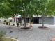 Landscaped backyard featuring mature trees, decorative gravel, outdoor kitchen and dining area at 5200 Wheatland Dr, Pahrump, NV 89061