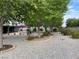 Expansive backyard featuring mature trees, gravel landscaping, and lush greenery for serene outdoor living at 5200 Wheatland Dr, Pahrump, NV 89061