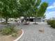 Backyard featuring lush trees, a built-in grill, and gravel landscape at 5200 Wheatland Dr, Pahrump, NV 89061