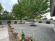 Backyard with mature trees, rock landscaping, potted plants, and a serene atmosphere at 5200 Wheatland Dr, Pahrump, NV 89061